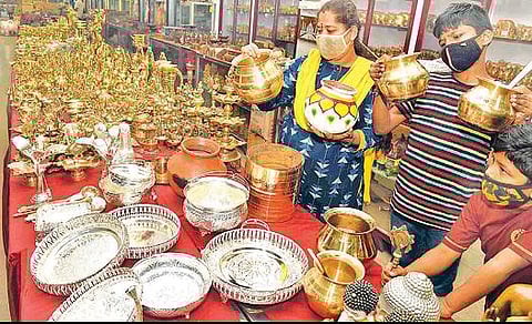 கோவை பூம்புகார் நிறுவனத்தில் நடைபெறும் பொங்கல் கண்காட்சியில் வைக்கப் பட்டுள்ள பொருட்களைப் பார்வையிட்ட பொதுமக்கள். படம்: ஜெ.மனோகரன்