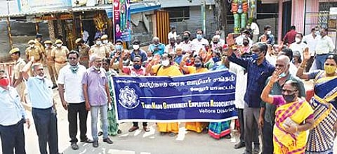 திருவண்ணாமலையில் நேற்று மறியலில் ஈடுபட்ட அரசு ஊழியர்கள். அடுத்த படம்: வேலூர் மாவட்ட ஆட்சியர் அலுவலகம் எதிரே மறியலில் ஈடுபட்ட தமிழ்நாடு அரசு ஊழியர் சங்கத்தினர். .