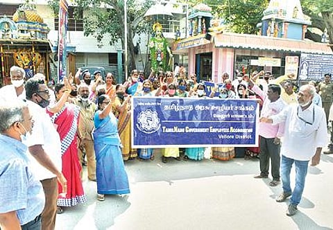 திருவண்ணாமலையில் 13 அம்ச கோரிக்கைகளை வலியுறுத்தி நேற்று சாலை மறியலில் ஈடுபட்ட அரசு ஊழியர்கள். அடுத்த படம்: வேலூர் மாவட்ட ஆட்சியர் அலுவலகம் எதிரே மறியலில் ஈடுபட்ட தமிழ்நாடு அரசு ஊழியர் சங்கத்தினர்.