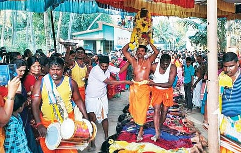 ஆவத்தவாடி கிராமத்தில் நடந்த மாரியம்மன் கோயில் திருவிழாவில் பக்தர்கள் மீது நடந்து சென்ற பூசாரி.