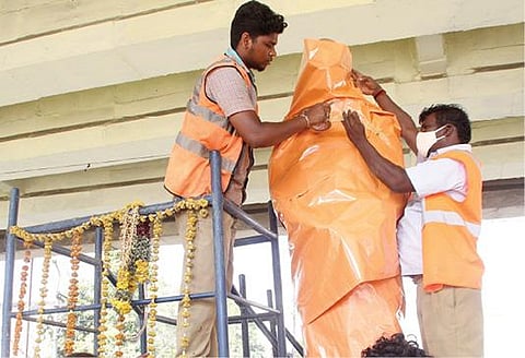 திருநெல்வேலியில் தேர்தல் நடத்தை விதிகள் அமலுக்கு வந்துள்ள நிலையில் வண்ணார்பேட்டையில் உள்ள செல்லபாண்டியன் சிலையை மாநகராட்சி ஊழியர்கள் மூடினர்.படம்: மு.லெட்சுமி அருண்