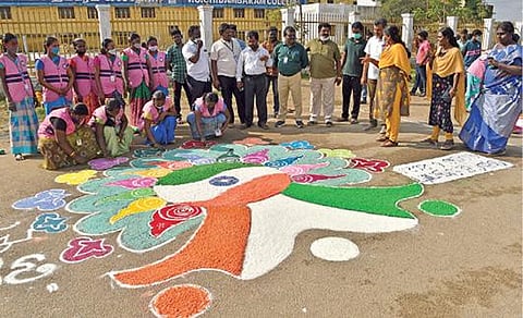 தேர்தலில் 100 சதவீத வாக்குப்பதிவை வலியுறுத்தி, தூத்துக்குடி வ.உ.சி.கல்லூரி மைதானத்தில், மாநகராட்சி பணியாளர்கள் ரங்கோலி கோலம் வரைந்தனர். படம்: என்.ராஜேஷ்.