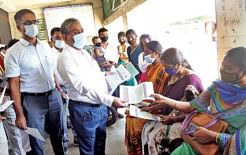 கோவை காந்திபுரம் நகரப் பேருந்து நிலைய வளாகத்தில் நேற்று பொதுமக்களுக்கு கரோனா நோய் தடுப்பு குறித்த துண்டுப் பிரசுரங்களை விநியோகித்த மாவட்ட ஆட்சியர் கு.ராசாமணி. அருகில், மாநகராட்சி ஆணையர் பெ.குமாரவேல் பாண்டியன் உள்ளிட்டோர். படம்:ஜெ.மனோகரன்