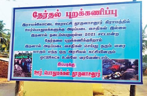 ராயக்கோட்டை அருகே தூருவாசனூர் கிராமத்தில் அடிப்படை வசதிகள் இல்லாததால், தேர்தலை புறக்கணிக்க போவதாக மக்கள் வைத்துள்ள பேனர்.