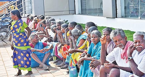 கள்ளக்குறிச்சியில் பிரச்சாரக் கூட்டம் ஒன்றில் பங்கேற்க வந்த தினக்கூலி தொழிலாளர்கள், கட்சியின் முக்கியஸ்தர் வருகைக்காக தியாகதுருகம் சாலையில் அமர்ந்திருக்கின்றனர்.