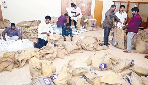 தேர்தல் பணிக்காக வாக்குச் சாவடி மையங்களுக்கு தேவைப்படும் பொருட்களை சாக்கு பையில் போட்டு அனுப்பும் பணியில் ஈடுபட்டுள்ள தேர்தல் அலுவலர்கள். இடம்: திருவல்லிக்கேணி என்.கே.டி பள்ளி.படம்: க.ஸ்ரீபரத்