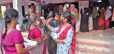 விருதுநகர் நகராட்சி முஸ்லிம் தொடக்கப் பள்ளி வாக்குச் சாவடி மையத்தில் வாக்காளர்களின் உடல் வெப்பத்தை கண்டறியும் சோதனை செய்யும் பெண் ஊழியர்.