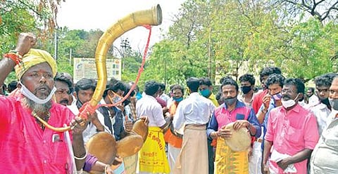 திருநெல்வேலியில் மாவட்ட ஆட்சியர் அலுவலகம் முன் கிராமிய கலைஞர்கள் இசைக்கருவிகளை இசைத்து கோரிக்கைகளை வலியுறுத்தி நூதன போராட்டத்தில் ஈடுபட்டனர். படம்: மு.லெட்சுமி அருண்