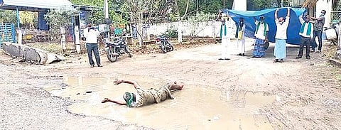 செய்யாறு கோட்டாட்சியர் அலுவலகம் முன்பு நெல் மூட்டைகளை பாதுகாக்க வலியுறுத்தி சேற்றில் உருண்டு நூதன போராட்டத்தில் ஈடுபட்ட விவசாயிகள்.