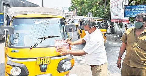 கரோனா தடுப்பூசி குறித்து விழிப்புணர்வு ஏற்படுத்தும் விதமாக, வேலூர் பழைய பேருந்து நிலையத்தில் ஆட்டோக்களில் விழிப்புணர்வு ஸ்டிக்கர் ஒட்டிய மோட்டார் வாகன ஆய்வாளர் கருணாநிதி. படம்: வி.எம்.மணிநாதன்.