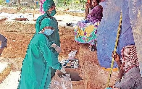 கொந்தகை அகழாய்வில் கண்டெடுக்கப்பட்ட முதுமக்கள் தாழியை ஆய்வு செய்யும் தொல்லியல் துறையினர்