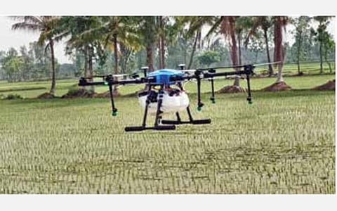 வயலில் டிரோன் மூலம் உரம் தெளிப்பு: ஆள் பற்றாக்குறையை சமாளிக்க விவசாயியின் புதிய யுக்தி