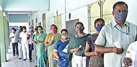 வாக்கு எண்ணும் பணியில் ஈடுபடும் பணியாளர்களுக்கு நேற்று சேலம் கோட்டை அரசு ஆண்கள் மேல்நிலைப் பள்ளியில் கரோனா பரிசோதனை முகாம் நடந்தது. இதில், பரிசோதனை செய்ய நீண்ட வரிசையில் காத்திருந்த அரசு அலுவலர்கள். படம்: எஸ்.குரு பிரசாத்