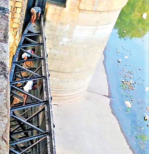 மேட்டூர் அணை 16 கண் மதகு பகுதியில் பராமரிப்புப் பணியில் ஈடுபட்டுள்ள பொதுப்பணித்துறை ஊழியர்கள்.