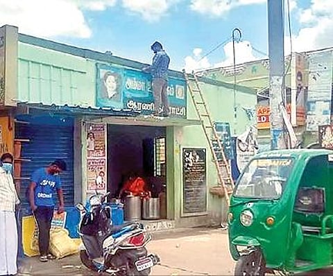 ஆரணியில் அம்மா உணவக பெயர் பலகை அகற்றப்பட்டது. அடுத்த படம்: அம்மா உணவக பெயர் பலகையை, மீண்டும் வைக்கும் பணியில் ஈடுபட்ட நகராட்சி ஊழியர்கள்.