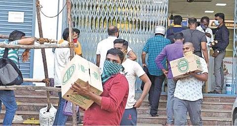 தமிழக அரசின் முழு ஊரடங்கு அறிவிப்பு: டாஸ்மாக் மதுக்கடைகளில் மதுபாட்டில்களை வாங்க திரண்ட வாடிக்கையாளர்கள்; பெட்டி, பெட்டியாக வாங்கிச் சென்றனர்