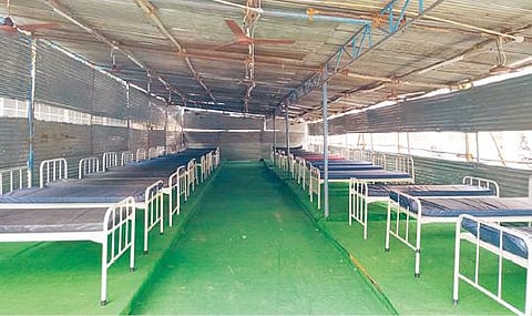 வேலூர் அரசு மருத்துவ கல்லூரி மருத்துவமனையில் கரோனா நோயாளிகளின் எண்ணிக்கை அதிகரித்து வரும் நிலையில், அவசர சிகிச்சை பிரிவு கட்டிடத்துக்கு எதிரே ஆக்சிஜன் இணைப்புடன் கூடுதல் படுக்கை வசதி கொண்ட தற்காலிக அரங்கை ஏற்படுத்தி வருகின்றனர். படம்: வி.எம்.மணிநாதன்.