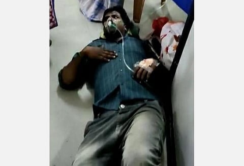 படுக்கை இல்லாமல் தரையில் படுத்து சிகிச்சை பெறும் கரோனா தொற்றாளர்.