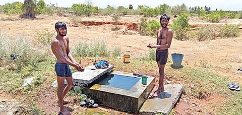 பரமத்தி அருகே சாலையோரத்தில் லாரியை நிறுத்தி கேட்வால்வில் கசியும் தண்ணீரில் ஆனந்த குளியல் போடும் லாரி ஓட்டுநர்கள். படம்: கி. பார்த்திபன்