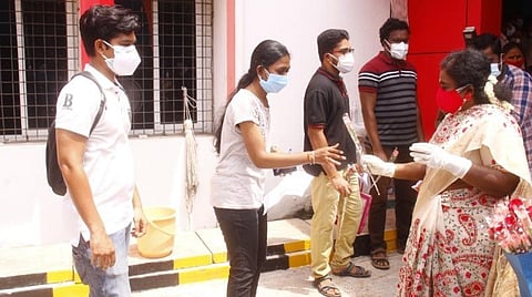 புதுச்சேரியில் கரோனா தடுப்பூசி செலுத்த வந்த இளையோருக்கு பூங்கொத்து தந்து வரவேற்கும் ஆளுநர் தமிழிசை