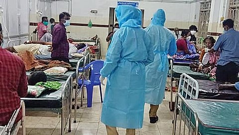 தேனி அரசு மருத்துவமனை கரோனா வார்டில் நோயாளிகளின் உதவியாளர்களை வெளியே செல்லுமாறு அறிவுறுத்திய பாதுகாப்பு உடை அணிந்த போலீஸார்.