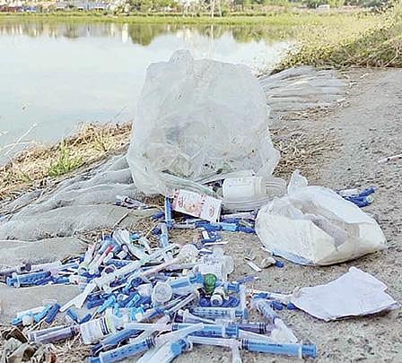 குளக்கரையில் கொட்டப்பட்டிருந்த மருத்துவக் கழிவுகள். படங்கள்: ஜெ.மனோகரன்