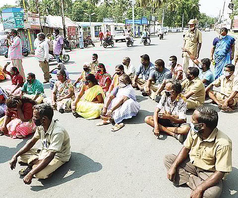 வேலூர் அண்ணா சாலையில் பெண் வியாபாரியை கண்டித்து, மறியலில் ஈடுபட்ட தூய்மை பணியாளர்கள்.படம்: வி.எம்.மணிநாதன்.