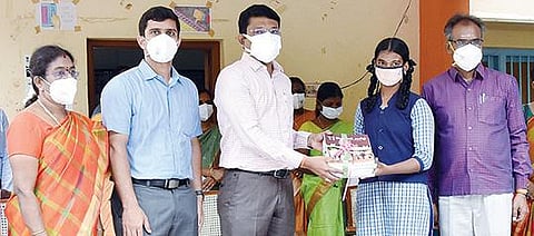 தி.மலை நகராட்சி அரசினர் பெண்கள் மேல்நிலை பள்ளியில் ஒரு மாணவிக்கு விலையில்லா பாடப்புத்தகங்களை வழங்கிய மாவட்ட ஆட்சியர் முருகேஷ். அருகில், மாவட்ட முதன்மை கல்வி அலுவலர் அருட்செல்வம் உள்ளிட்டோர்.