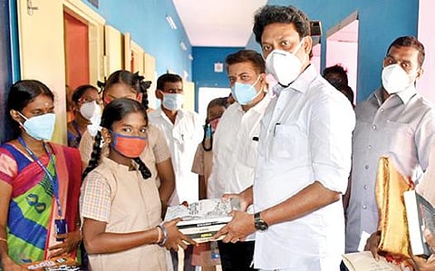 திருச்சி எடமலைப்பட்டி புதூர் ஊராட்சி ஒன்றியத் தொடக்கப் பள்ளியில் நேற்று மாணவி ஒருவருக்கு பாடப் புத்தகங்களை வழங்குகிறார் அமைச்சர் அன்பில் மகேஸ் பொய்யாமொழி.படம்: ஜி.ஞானவேல்முருகன்