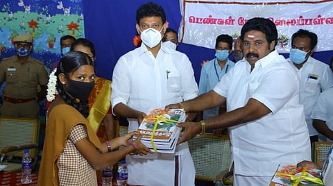 மாணவிக்குப் பாடப் புத்தகத்தை வழங்கினார் அமைச்சர் அன்பில் மகேஸ் பொய்யாமொழி. உடன் எம்.பழனியாண்டி எம்எல்ஏ.