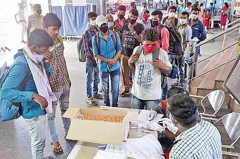 கோவை ரயில்நிலையத்தில் கரோனா பரிசோதனை மேற்கொள்வதற்காக நேற்று காத்திருந்த வடமாநில தொழிலாளர்கள். படம்: ஜெ.மனோகரன்