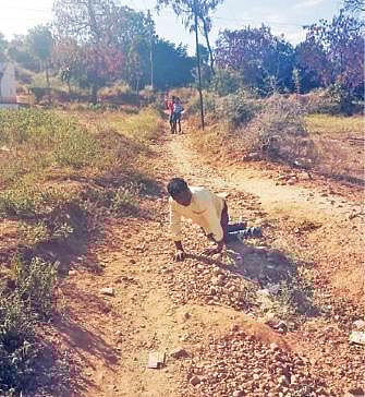 தருமபுரி மாவட்டம் ஏரியூர் அடுத்த அண்ணா நகர் பகுதியில் சாலை வசதியின்றி தவித்த மாற்றுத் திறனாளி. அடுத்த படம்: அவரது ட்விட்டர் கோரிக்கையை ஏற்று மேற்கொள்ளப்பட்டு வரும் சாலைப்பணி.