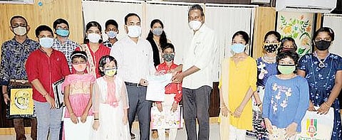 சிவகங்கை மாவட்ட ஆட்சியர் அலுவலகத்தில் ஆட்சியர் பி.மதுசூதன்ரெட்டியிடம் ஓவியங்கள் விற்ற பணத்தை முதல்வரின் கரோனா நிவாரண நிதிக்கு வழங்கிய குழந்தைகள்.