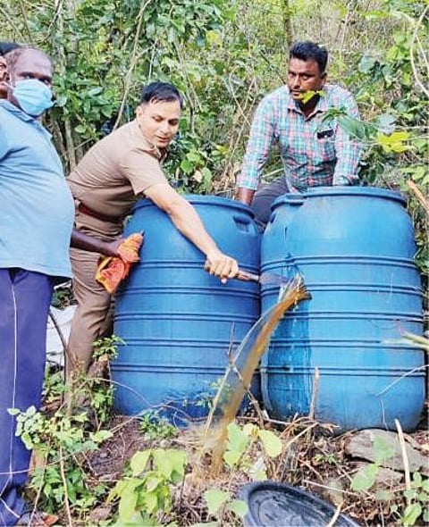 கல்வராயன்மலையில் பறக்கும் கேமரா மூலம் கண்டுபிடிக்கப்பட்ட கள்ளச்சாராய ஊரலை அழிக்கும் போலீஸார் .