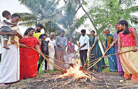 ஆடி மாதப்பிறப்பையொட்டி, சேலத்தில் நேற்று தேங்காய் சுடும் நிகழ்வு நடந்தது. மன்னார் பாளையம் தோப்புக்காடு பகுதியில் உறவினர்களுடன் புதுமண தம்பதி தேங்காயை சுட்டனர். படம்: எஸ்.குரு பிரசாத்
