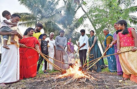ஆடி மாதப்பிறப்பையொட்டி, சேலத்தில் நேற்று தேங்காய் சுடும் நிகழ்வு நடந்தது. மன்னார்பாளையம் தோப்புக்காடு பகுதியில் உறவினர்களுடன் புதுமண தம்பதி தேங்காயை சுட்டனர். படம்: எஸ்.குரு பிரசாத்