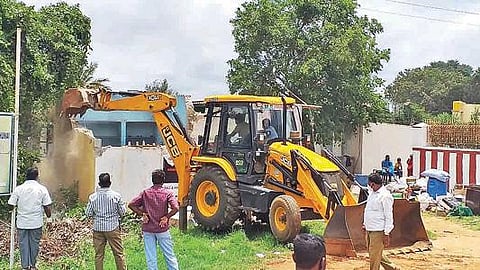 அரசு நிலத்தை ஆக்கிரமித்து கட்டிய வீட்டை இடித்து அகற்றும் பணியில் ஈடுபட்ட நெடுஞ்சாலைத்துறை மற்றும் வருவாய் துறையினர். படம்: ஜோதி ரவிசுகுமார்.