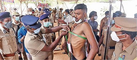 கோவை பி.ஆர்.எஸ் மைதானத்தில் நடைபெற்ற காவலர் உடல்தகுதி தேர்வில், இளைஞரின் மார்பளவை சரிபார்க்கும் காவலர். படம்: ஜெ.மனோகரன்