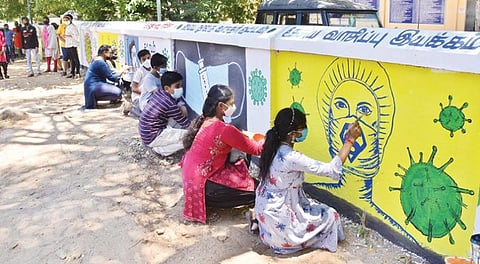 திருநெல்வேலி மாவட்ட மைய நூலகச் சுவரில் கரோனா விழிப்புணர்வு ஓவியங்கள் வரையும் மாணவ, மாணவிகள். படம்: மு.லெட்சுமி அருண்