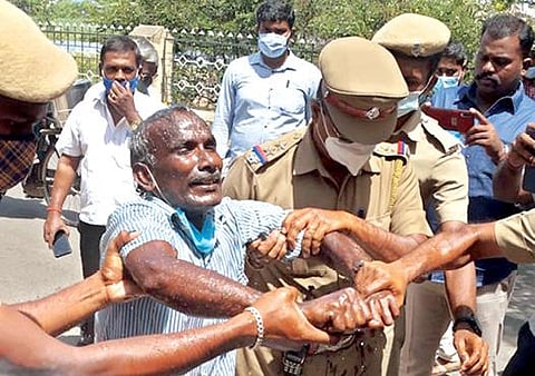 திருநெல்வேலி ஆட்சியர் அலுவலகத்தில் மண்ணெண்ணெய் ஊற்றி தீக்குளிக்க முயன்ற நபரை போலீஸார் மீட்டனர். படம்: மு.லெட்சுமி அருண்.