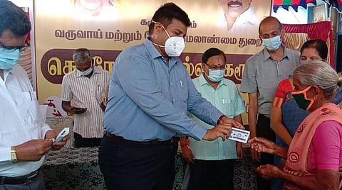 கரூர் தாந்தோணிமலை ரேஷன் கடையில் மாவட்ட ஆட்சியர் த.பிரபுசங்கர், மூதாட்டிக்கு ரேஷன் அட்டைக்கான கரோனா விழிப்புணர்வு வாசகங்கள், படங்கள் அடங்கிய பவுச்சை வழங்கினார்.