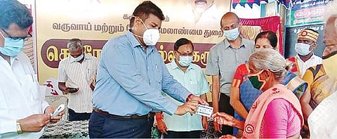 கரூர் தாந்தோணிமலை ரேஷன் கடையில் நேற்று நடைபெற்ற நிகழ்ச்சியில் ஒரு மூதாட்டிக்கு ரேஷன் கார்டுக்கான பாதுகாப்பு உறையை வழங்குகிறார் மாவட்ட ஆட்சியர் த.பிரபுசங்கர். (உள்படம்) ரேஷன் கார்டு பாதுகாப்பு உறை.