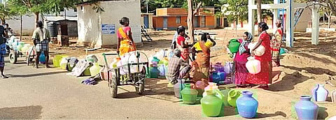 காளையார்கோவில் அருகே கோலாந்தி கிராமத்தில் தண்ணீர் பிடிக்க குடங்களுடன் காத்திருக்கும் கிராம மக்கள்.