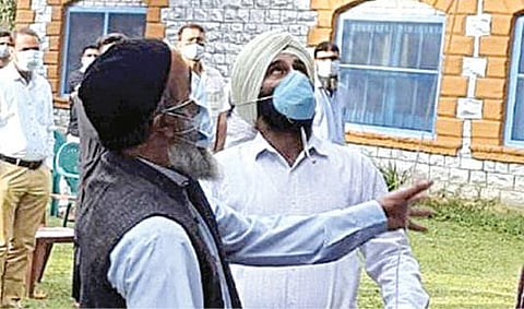 என்கவுன்ட்டரில் சுட்டுக் கொல்லப்பட்ட தீவிரவாதி புர்ஹான் வானியின் தந்தை முசாபர் வானி (இடது), அரசு பள்ளியில் நேற்று தேசிய கொடியேற்றினார்.