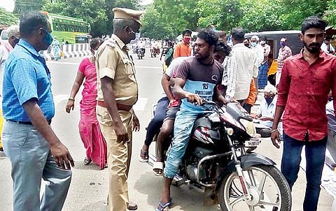 தி.மலை மாவட்ட ஆட்சியர் அலுவலக பேருந்து நிறுத்தம் அருகே முகக்கவசம் அணியாமல் இரு சக்கர வாகனத்தில் வந்த 3 பேருக்கு அபராதம் விதிக்கப்பட்டது. படம்: இரா.தினேஷ்குமார்.