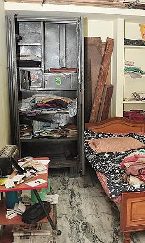 விஜயராகவன் வீட்டில் பீரோ உடைக் கப்பட்டு அதிலிருந்த பொருட்கள் சிதறிக்கிடக்கின்றன.