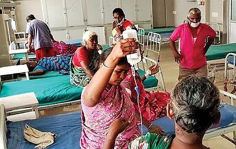 சிவகங்கை அரசு மருத்துவமனையில் நோயாளிக்கு ஏற்றும் குளுக்கோஸ் பாட்டிலை கையில் பிடித்துள்ள உறவினர்.