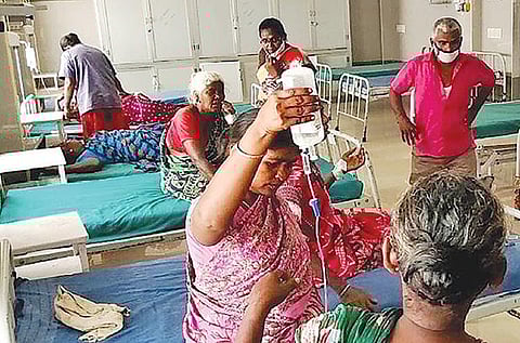 சிவகங்கை அரசு மருத்துவமனையில் நோயாளிக்கு ஏற்றும் குளுக்கோஸ் பாட்டிலை கையில் பிடித்துள்ள உறவினர்.