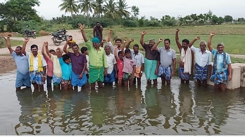 தண்ணீரில் இறங்கி முகத்தில் மண்ணைப் பூசிக் கொண்டு ஆர்ப்பாட்டத்தில் ஈடுபட்ட விவசாயிகள்.