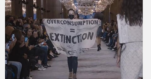 ஃபேஷன் ஷோவில் காலநிலை மாற்றத்திற்கு எதிரான வாசகத்தை தாங்கி நடந்த பெண்: வெளியேற்றிய காவலர்கள்